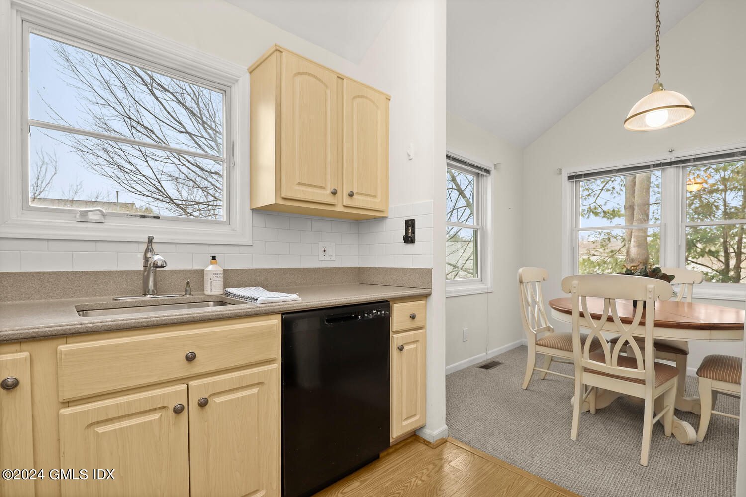 351 Pemberwick Road, Unit 915 Greenwich, CT 06831 - Photo 8 of 19 a kitchen with a sink cabinets and dining table