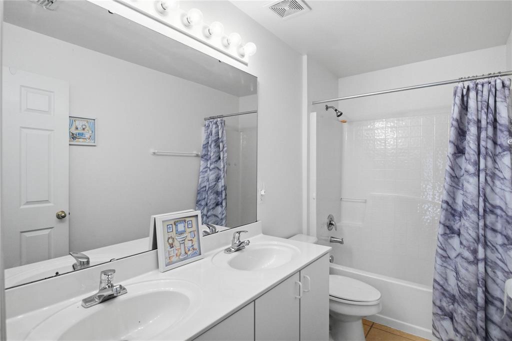 206 Taranto Way Kissimmee, FL 34758 - Photo 34 of 45 a bathroom with a sink toilet double vanity and shower