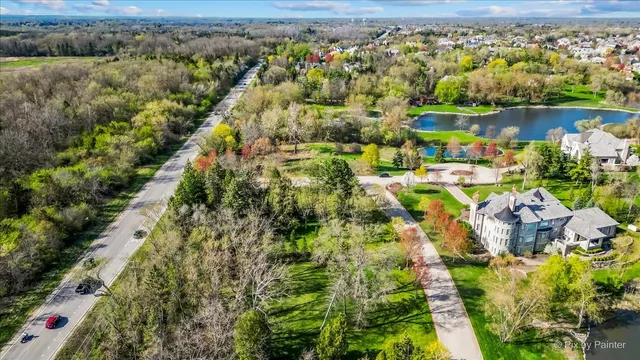 an aerial view of residential houses with outdoor space and lake view