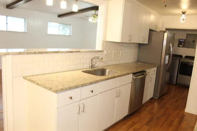 a kitchen with stainless steel appliances granite countertop a sink stove and refrigerator