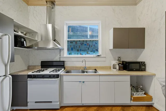 an aerial view of a house with a yard and trees all around