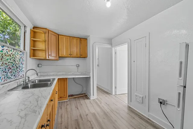 a view of an empty room with wooden floor and windows