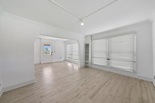 a kitchen with stainless steel appliances granite countertop a stove top oven a sink dishwasher and a refrigerator with wooden floor