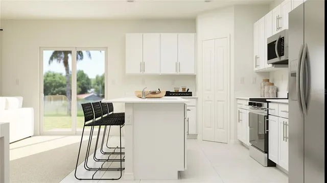 a kitchen with a refrigerator a stove cabinets and a dining table
