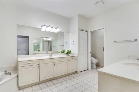 a spacious bathroom with a double vanity sink mirror and toilet
