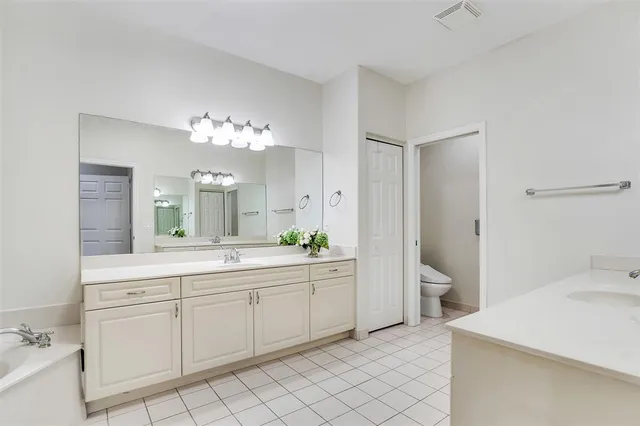 a spacious bathroom with a double vanity sink mirror and toilet