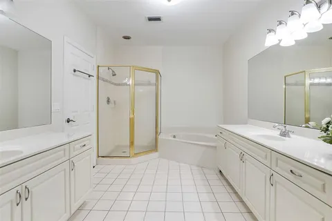 a spacious bathroom with a granite countertop sink mirror and a bathtub