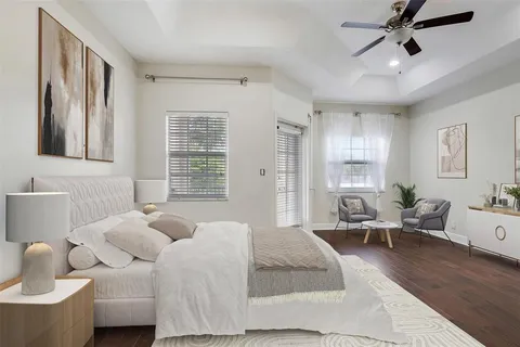a spacious bedroom with a bed and wooden floor