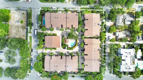 an aerial view of residential houses with outdoor space and parking