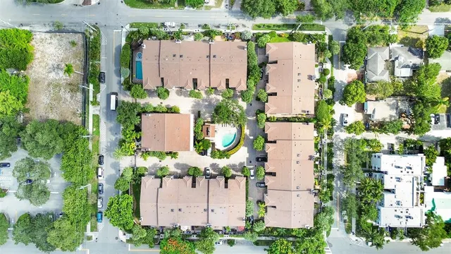 an aerial view of residential houses with outdoor space and parking