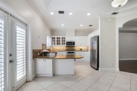 a kitchen with stainless steel appliances kitchen island granite countertop a refrigerator and a sink
