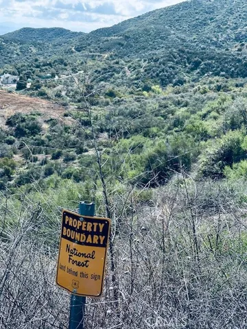 a view of a sign board in middle of forest