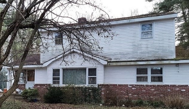 a front view of a house with a garden