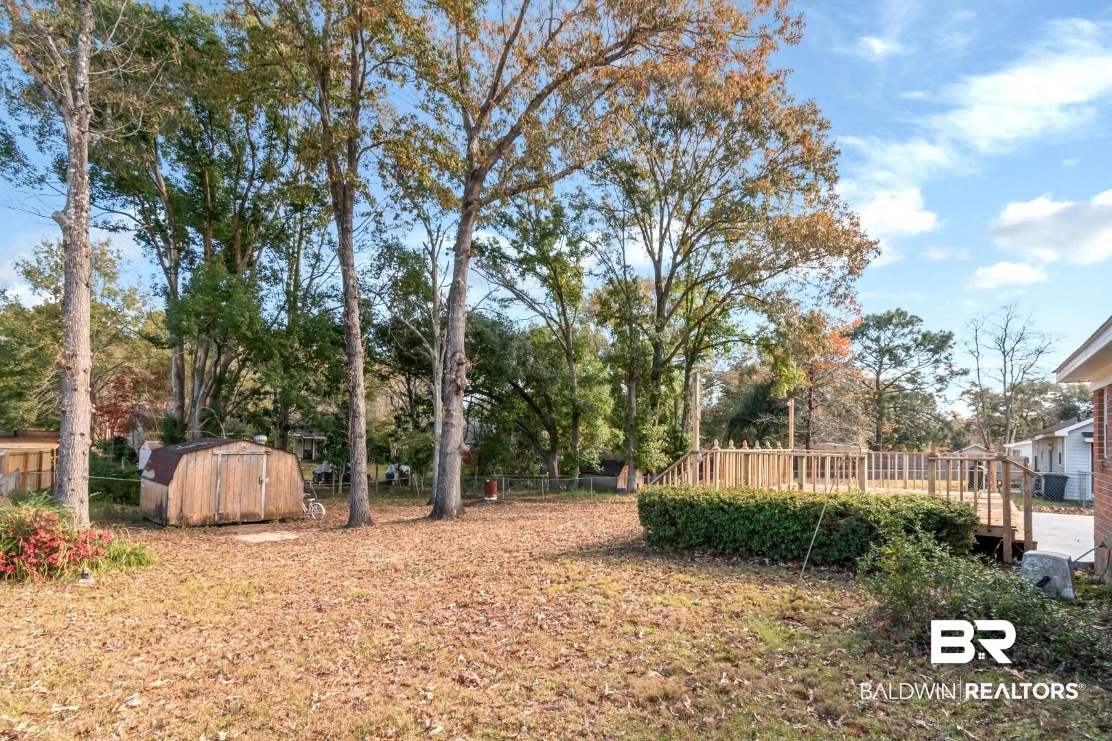 9360 Burnt Tree Drive Mobile, AL 36695 - Photo 25 of 28 View of yard featuring a storage unit and a wooden deck