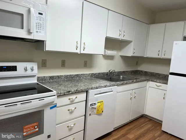 a kitchen with granite countertop a stove sink and cabinets