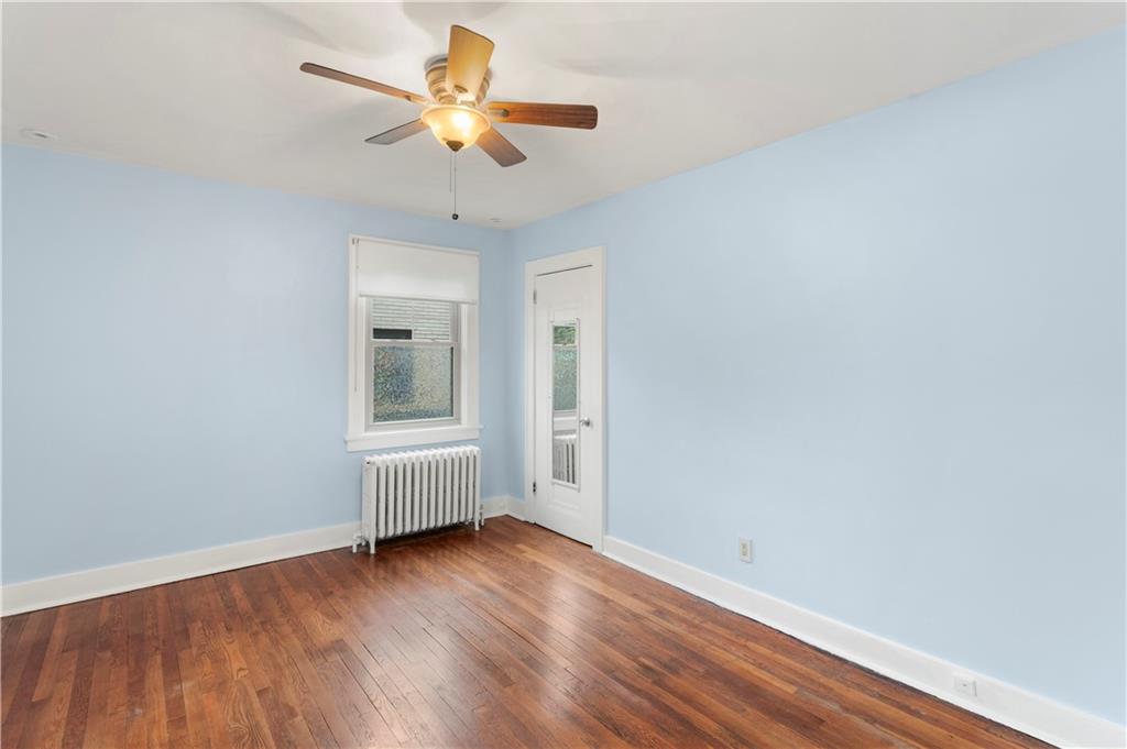 6953 Reynolds Street Pittsburgh, PA 15208 - Photo 24 of 50 an empty room with wooden floor chandelier fan and windows