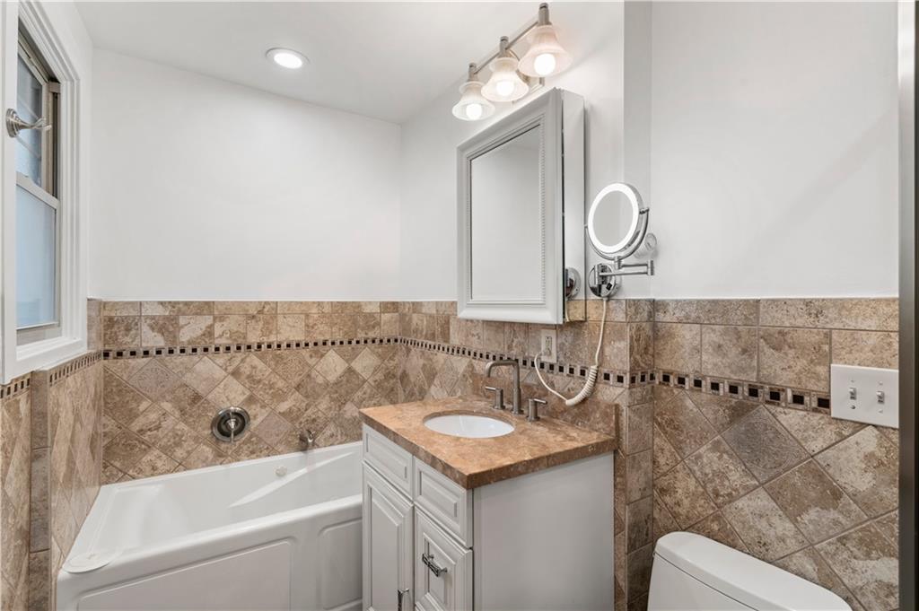 6953 Reynolds Street Pittsburgh, PA 15208 - Photo 33 of 50 a bathroom with a bathtub a sink and a mirror