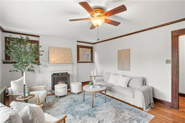 a living room with furniture a ceiling fan and a window