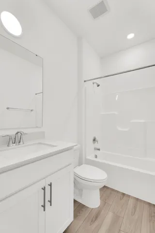 a bathroom with a white toilet sitting next to a bathroom sink and a shower