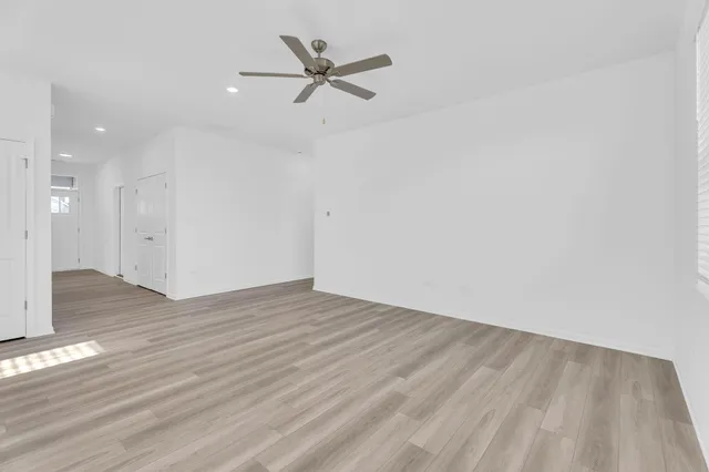 a view of a big room with wooden floor a ceiling fan