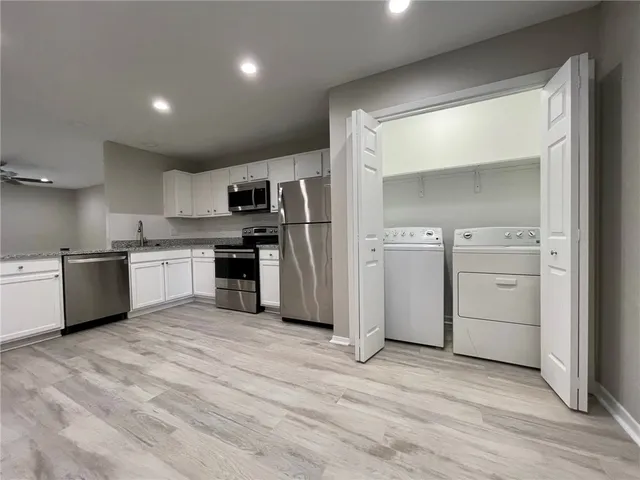 a kitchen with stainless steel appliances granite countertop a stove a sink and a refrigerator