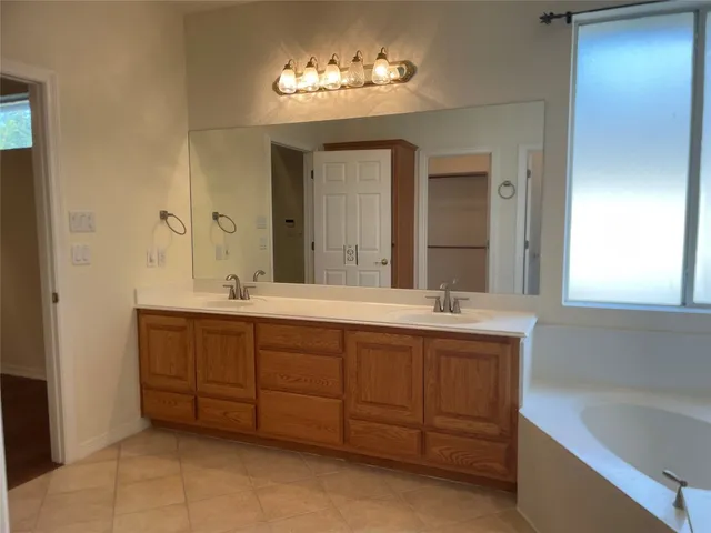 a bathroom with a tub sink and mirror