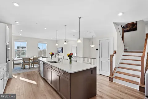 a kitchen with stainless steel appliances granite countertop a sink counter and chairs