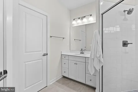 a bathroom with a double vanity sink mirror and shower