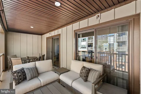 a balcony with furniture and large windows