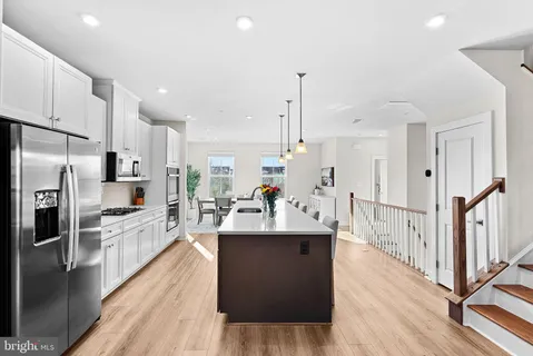a large kitchen with stainless steel appliances kitchen island granite countertop a large counter top stainless steel appliances and wooden floor