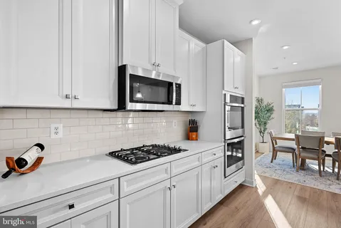 a kitchen with cabinets appliances a sink and a counter space