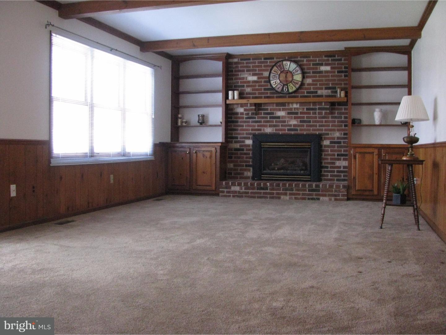 11 Raphael Road Hockessin, DE 19707 - Photo 6 of 25 a living room with furniture a fireplace and a window