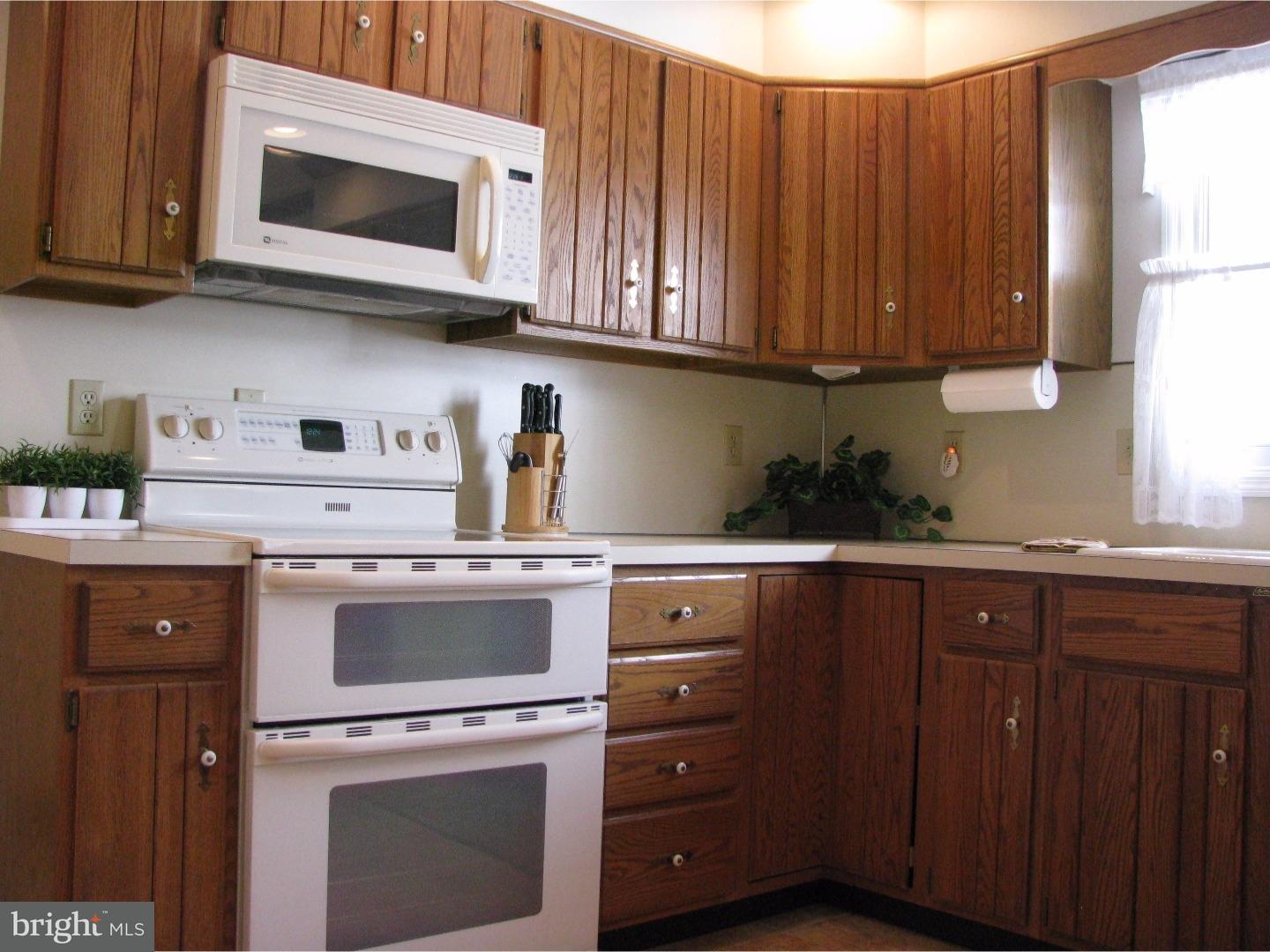 11 Raphael Road Hockessin, DE 19707 - Photo 10 of 25 a kitchen with stainless steel appliances granite countertop a sink a stove and microwave