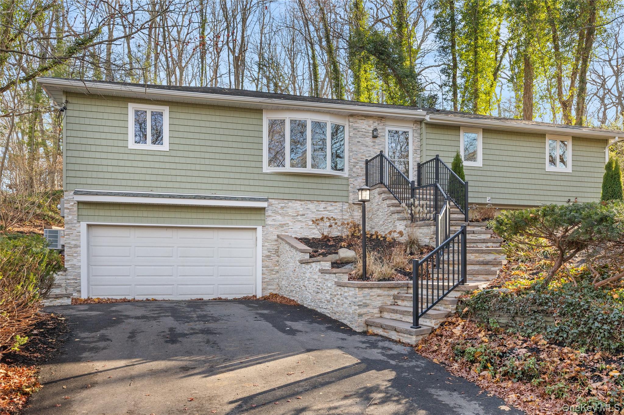 142 Crooked Hill Road Huntington Station, NY 11746 - Photo 1 of 18 View of front of home with stone siding, driveway, and an attached garage
