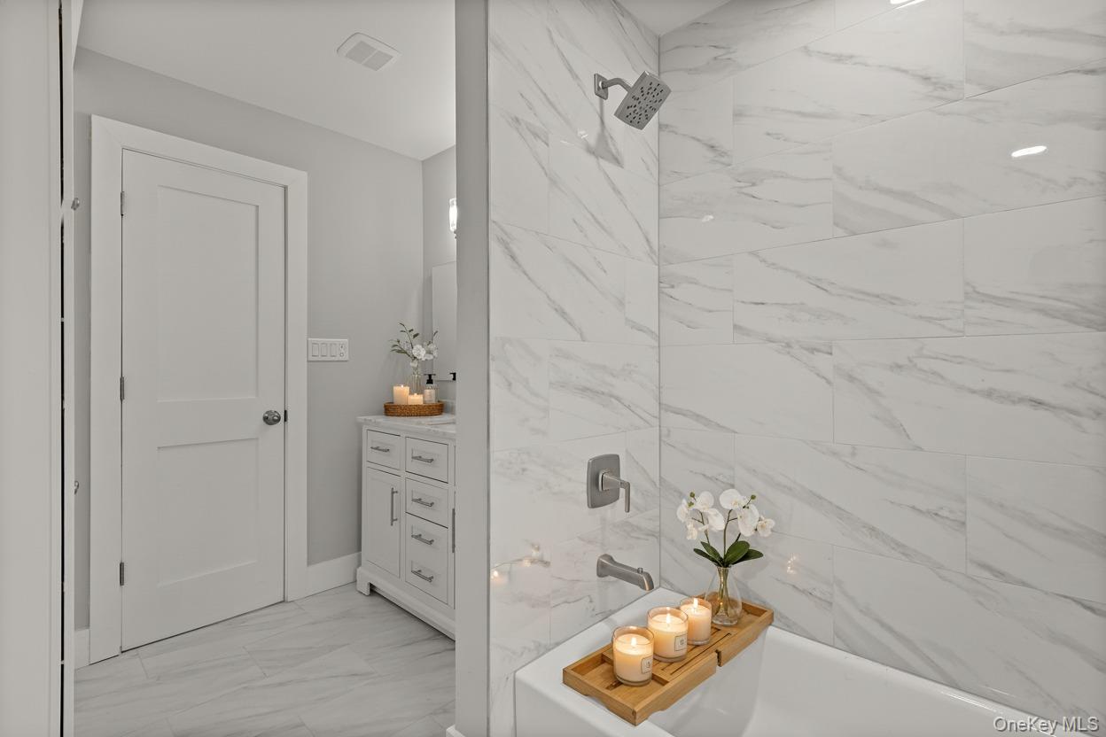 142 Crooked Hill Road Huntington Station, NY 11746 - Photo 13 of 18 Bathroom with vanity, light marble finish floors, and shower / bath combination