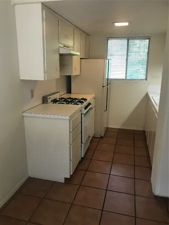 a kitchen with a stove a refrigerator and cabinets