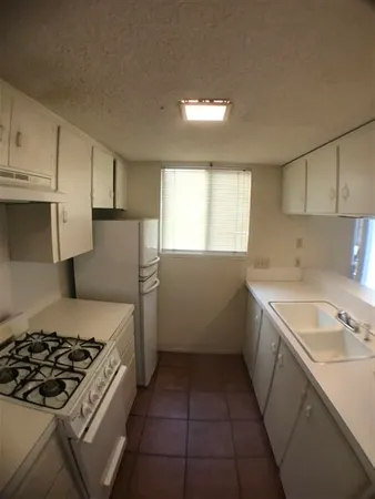 a kitchen with a sink stove and cabinets