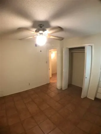 an empty room with closet and a chandelier fan