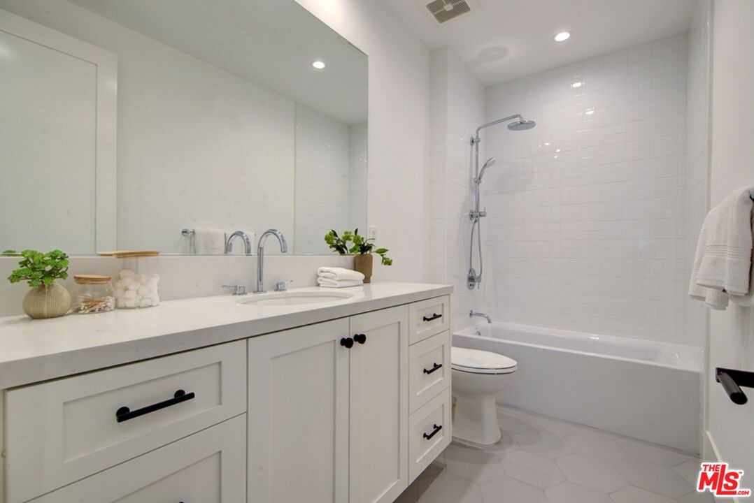 10810 Valley Spring Lane Studio City, CA 91602 - Photo 24 of 36 a bathroom with a double vanity sink toilet and shower