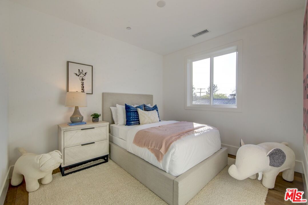 10810 Valley Spring Lane Studio City, CA 91602 - Photo 25 of 36 a bedroom with a bed and a window