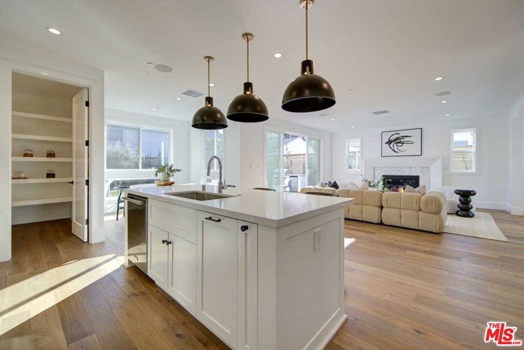 10810 Valley Spring Lane Studio City, CA 91602 - Photo 7 of 36 a kitchen with stainless steel appliances granite countertop a sink a stove and a wooden floors