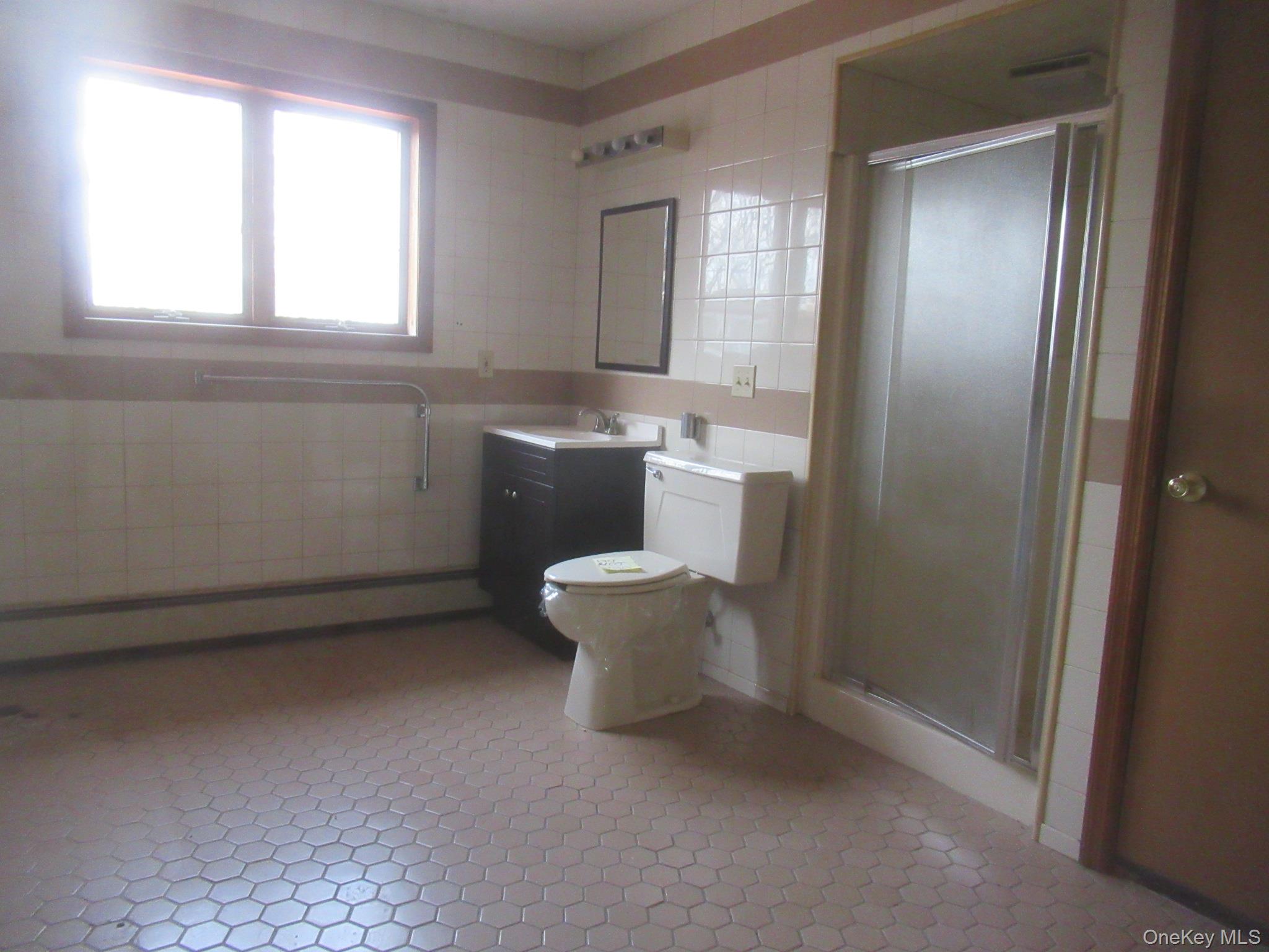 64 Hillside View Road Mahopac, NY 10541 - Photo 11 of 25 Bathroom with tile walls, vanity, a stall shower, and a baseboard heating unit