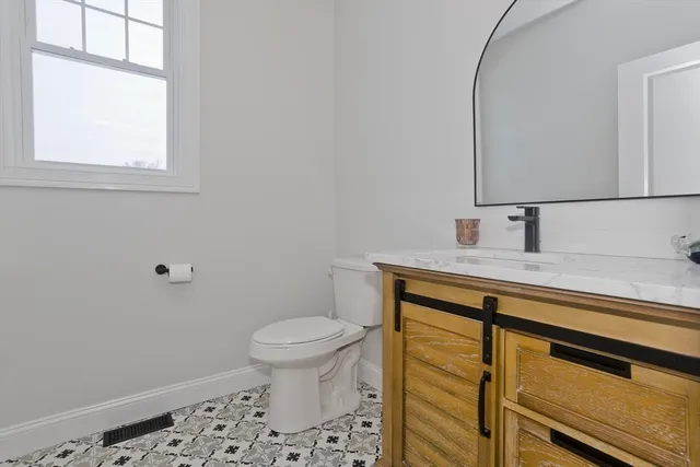 a bathroom with a sink a toilet and a mirror