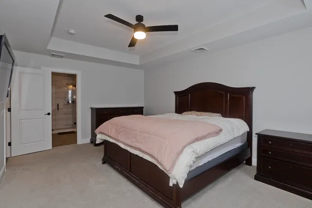 a bedroom with a large bed and a chandelier