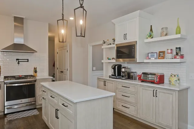 a kitchen with cabinets stainless steel appliances and wooden floor