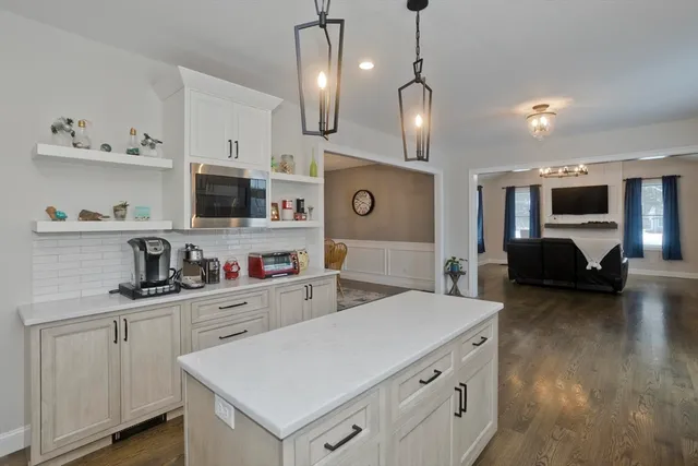 a kitchen that has a lot of cabinets and wooden floor