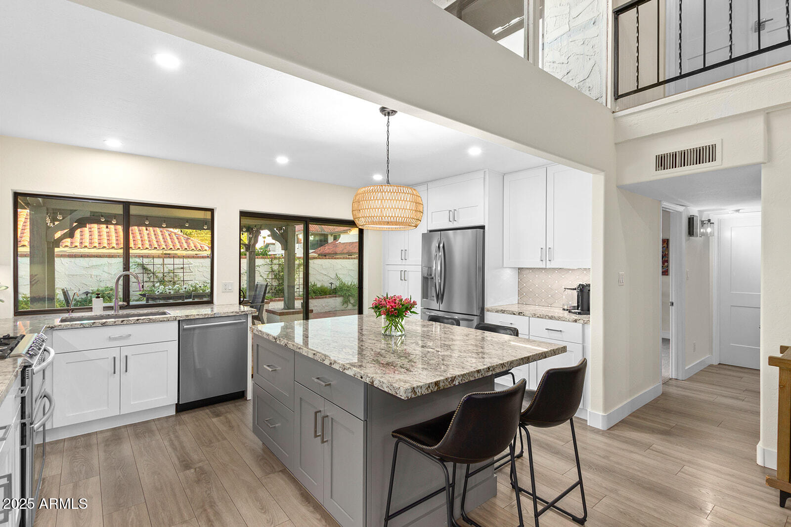 5822 North Scottsdale Road Paradise Valley, AZ 85253 - Photo 12 of 32 a kitchen with granite countertop center island wooden floor and stainless steel appliances
