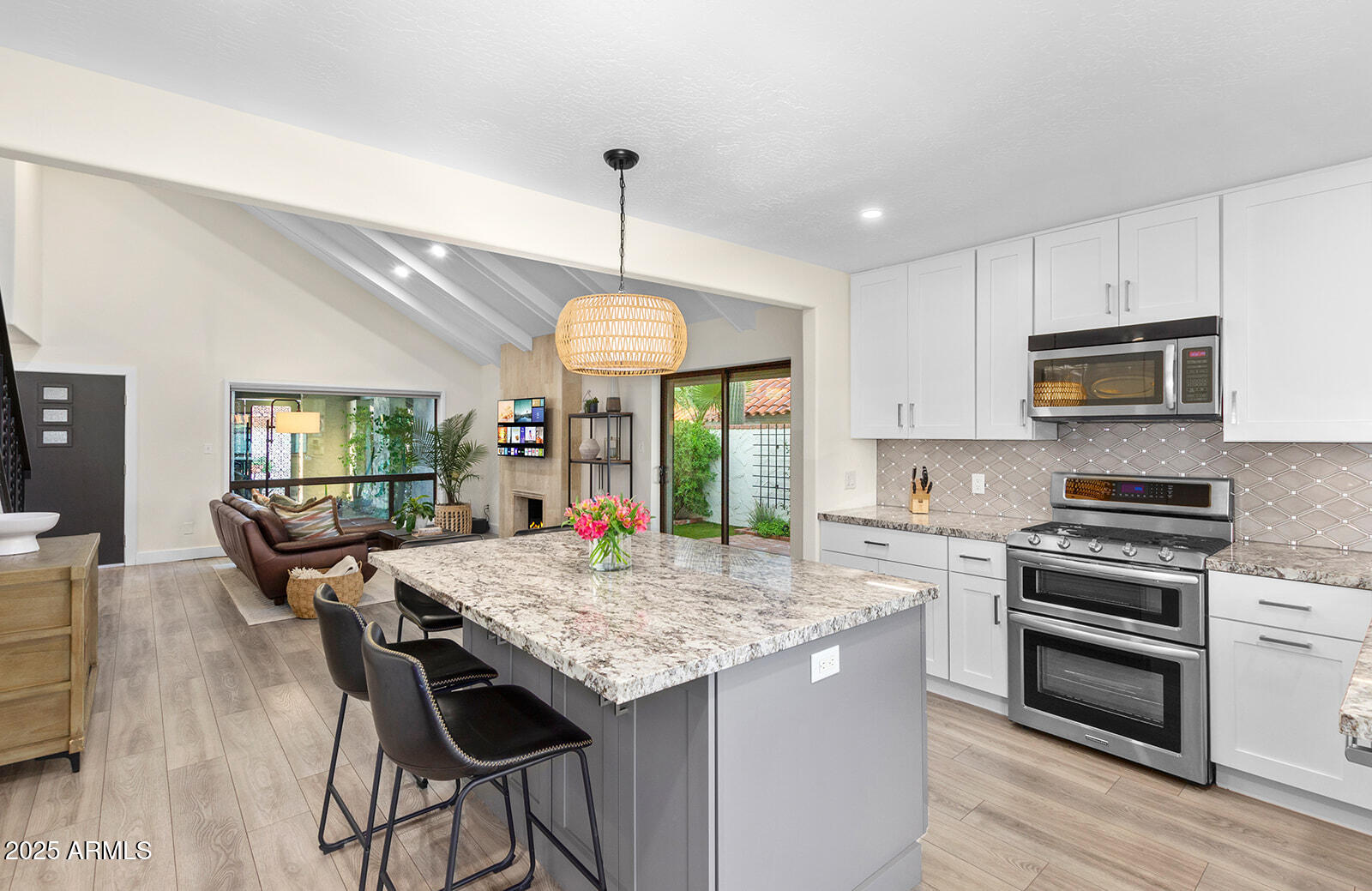 5822 North Scottsdale Road Paradise Valley, AZ 85253 - Photo 10 of 32 a kitchen with kitchen island granite countertop a sink a stove a dining table and chairs with wooden floor