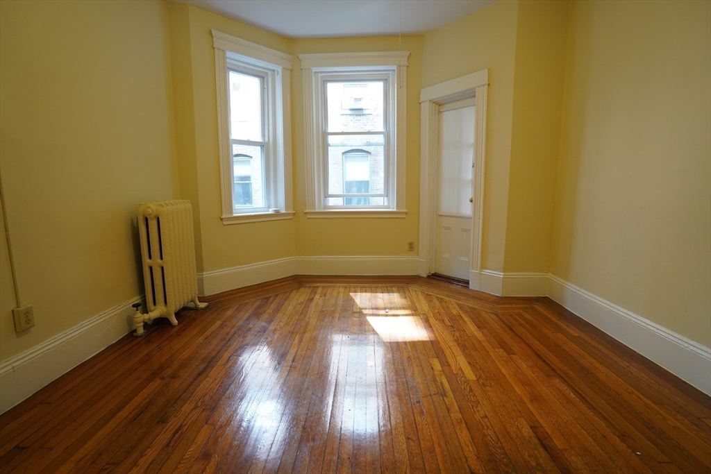 11 Royce Road, Unit 12 Boston, MA 02134 - Photo 1 of 7 an empty room with wooden floor and windows
