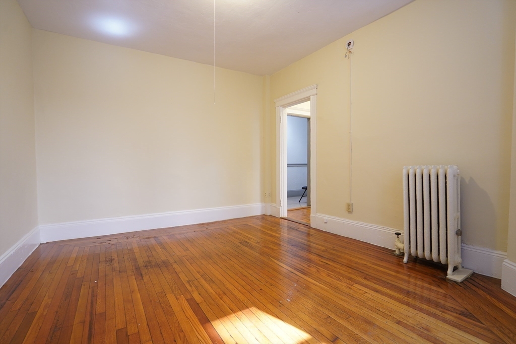 11 Royce Road, Unit 12 Boston, MA 02134 - Photo 4 of 7 a view of an empty room with wooden floor
